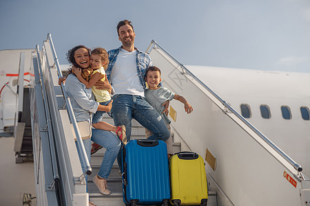四人家庭快乐的景象 白天从飞机上下飞机图片