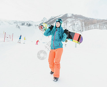 在滑雪度假胜地有雪板的妇女图片