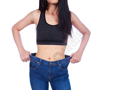 女人的特写展示了她的体重减轻 穿着白色背景中突显的旧牛仔裤腹部女性身体女孩腰部数字重量饮食成人减肥图片