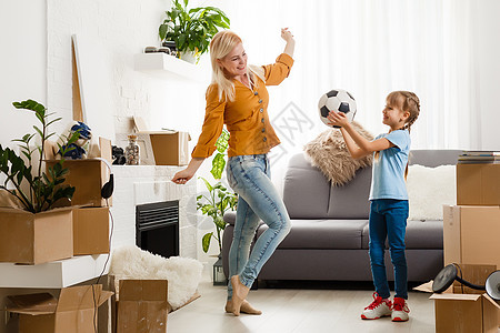 漂亮的年轻母亲和可爱的小女儿 在新公寓玩得开心 拆开搬家的箱子抵押情绪地面财产服务乐趣女孩搬迁开箱房子图片