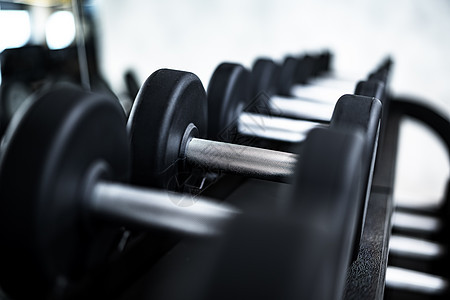 在健身房的架子上 紧贴着新的哑铃杠铃俱乐部房间火车身体肌肉训练运动权重金属图片