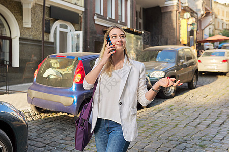 年轻美丽的女士在城市街上走动 用手机交谈街道女性经理电话中心商务商业工人互联网细胞图片
