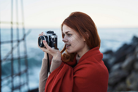 妇女带着毯子躲藏在自然界上 带照相机的休假摄影师旅行码头海岸线海滩游客天空旅游摄影电脑照片技术图片