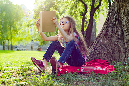 戴眼镜的女童在公园阅读书童年女性幸福孩子教育女孩孩子们学校文学青年图片