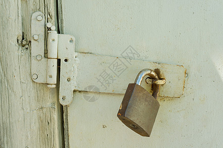 把手五金Rusty特写了旧木制白色黑漆门的锁背景