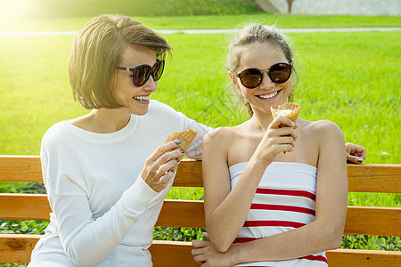 快乐的年轻母亲和少女可爱的女儿 在一个城市公园 吃冰淇淋 说话和大笑假期青少年成人女朋友奶油晴天乐趣食物女孩街道图片