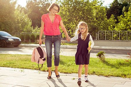 母亲和女儿学生步行去上学图片