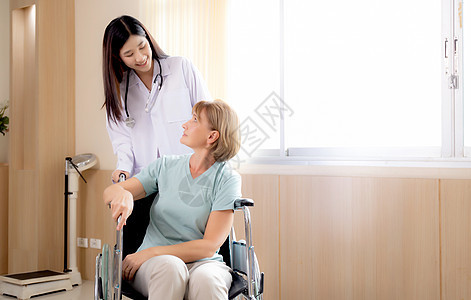 女医生在医院鼓励和照顾坐在轮椅上的病人 医生对老年人友好 诊断疾病和疾病 医疗保健 室内 医疗理念图片