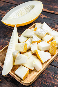 木托盘上切片黄瓜的立方体 黑木背景热带甜点甜瓜饮食黄色食物水果图片