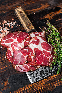 Coppa Capocollo Capicollo 用肉刀割火腿 黑木背景香料香肠乡村美食熏制猪肉草本植物木板熟食熏肉图片