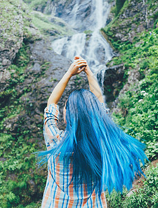 有蓝色头发的女孩 享受着瀑布的风景图片