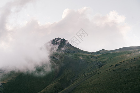 山上的云层天空爬坡顶峰草地绿色图片