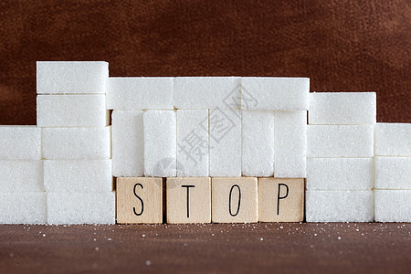 堆糖块或糖块墙 并在大写字母中停用单词作为关于成瘾卡路里过量和甜食不健康食物滥用导致健康问题和超重背景的建议厨房糖尿病疾病营养警背景图片