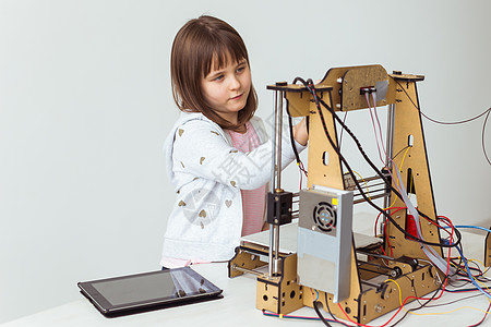 3D印有百叶窗的可爱女孩正在看她的3D打印机 因为它打印了3D模型教育学习智力塑料设计师天才创造力机器成就玩具图片