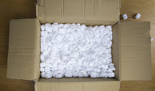 装有包装泡沫顶视图的纸板箱 木制桌上易碎产品的交货箱材料货运邮政导游商业邮件纸盒颗粒纸板回收图片