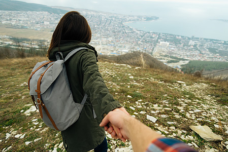 女旅游者握着男人的手 领导他追求自然图片