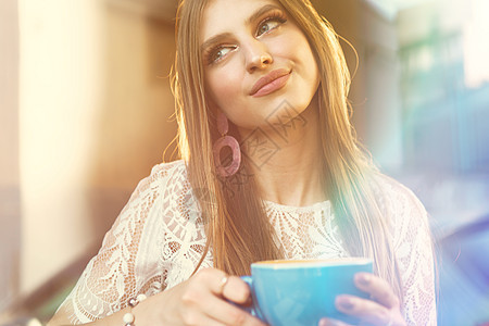 一个年轻女子的肖像 喝杯咖啡 透过窗户看望着她的身影巧克力女性酒吧饮料成人玻璃咖啡店早餐闲暇芳香图片