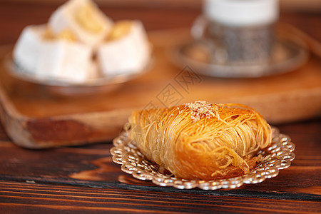 棕色木制背景的小盘子上土耳其甜食宏观糖果坚果小吃桌子美食静物面包糕点蜂蜜图片