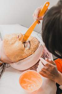 美容院的温泉疗养 是一位专业美容师在客户脸上戴金面罩的手女士福利治疗师毛巾面具眼睛胶原化妆品护理皮肤图片