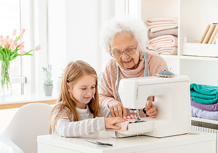 外祖母教孙子缝衣服孙女祖母女裁缝女孩女性职业帮助母亲老年长老背景图片