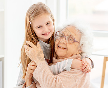 抱着奶奶的小女孩妈妈荣誉女孩沉思父母拥抱老年孙女成人祖母图片