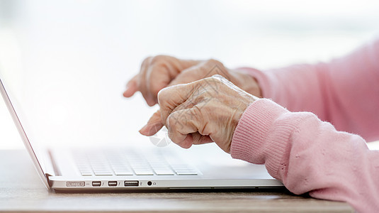 拥有膝上型电脑的高级妇女专注技术女性长老自由职业者退休阅读桌子成人互联网图片