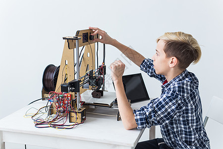 教育 儿童 技术概念     少年男孩正在印刷3D打印机青少年班级创造力男生电子产品力学快乐机器人童年3d图片