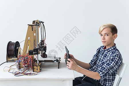 教育 儿童 技术概念     少年男孩正在印刷3D打印机力学男生机器人快乐商业孩子男性班级学习建设图片