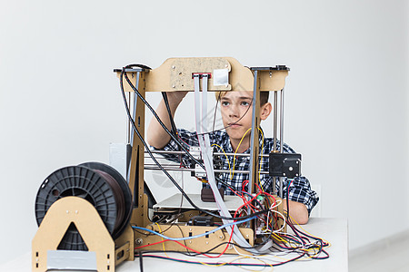 教育 儿童 技术概念     少年男孩正在印刷3D打印机建设创造力男性快乐3d童年青少年孩子作坊学生图片