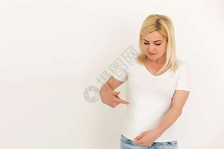 女人在白色T恤上露出一个斑点汗斑汗渍手势手指洞察力女性尴尬头发浸泡棕色图片