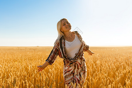 一个女孩在小麦口袋里 白人女人在外面摆着小燕子日落谷物农村女孩地平线钦佩粮食极乐农业太阳图片