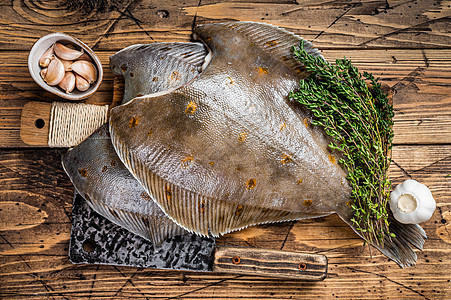 屠宰板上挂有刀子的扁鱼 木质背景木板黑色棕色白色食物百里香迷迭香烹饪鲽鱼海洋图片