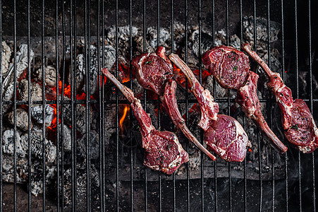 在烧烤时煮生羊排牛排 在户外用火烧烤BBQ烤肉架子油炸肋骨羊肉野餐烹饪草本植物火焰釉面煤炭图片