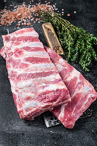 肉类切肉刀上未烹煮的生猪肉备用肋骨 黑色背景食物草本植物营养猪肉烧烤厨房香料木板美食烹饪图片