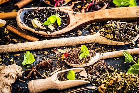 黑桌上的茶勺子木槿草本植物食物早餐芳香水果薰衣草植物团体背景图片