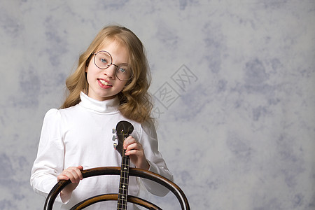 可爱的小女孩在玩多姆布拉民间学校草原女孩戏服女儿音乐家男人艺术乐队图片