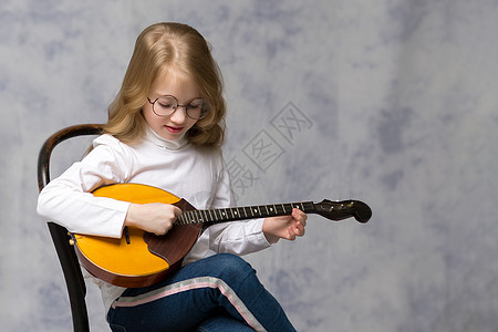 可爱的小女孩在玩多姆布拉男人女孩音乐戏服音乐家女士学校沙皮草原裙子图片