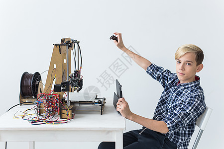 教育 儿童 技术概念     少年男孩正在印刷3D打印机建设男生数字打印孩子工程3d快乐机器人创造力图片