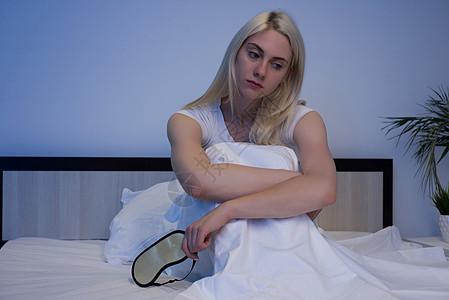 睡眠障碍 失眠 患有抑郁症的妇女穿着睡衣坐在床上  图片女孩疼痛枕头健康邻居唤醒白色婚姻噪音面具图片