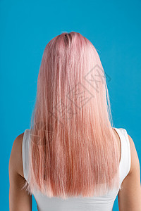 年轻女子的头发染色 站在蓝工作室背景旁 与世隔绝 她被隔离了图片