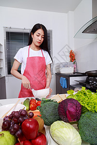 妇女烹饪和在厨房的碗里煮鸡蛋烘烤鞭打平底锅厨师玻璃面包美食成人水果桌子图片