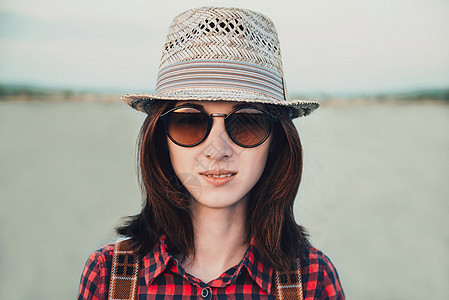 戴墨镜戴帽子的女人的肖像图片