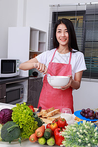 妇女烹饪和在厨房的碗里煮鸡蛋女性美食水果烘烤蔬菜糕点食物玻璃成人桌子图片