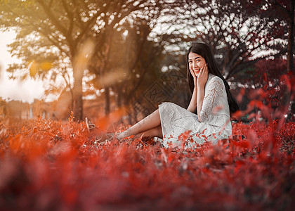 公园中美丽的女人的肖像树叶女孩叶子微笑裙子森林女性橙子幸福阳光图片
