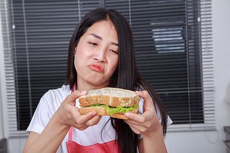 厨房里有女人吃三明治蔬菜女士午餐沙拉小吃营养早餐女性成人食物图片