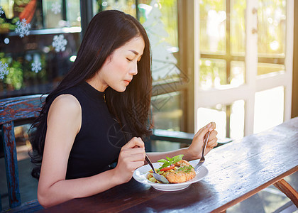 妇女在餐馆里吃食物白色女孩午餐面条咖啡店桌子饮食餐厅黑色女性图片