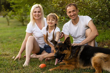 一个大家庭的肖像和他们的宠狗坐在公园旁的宠狗父母男性动物宠物兄弟姐妹孩子男人快乐姐姐微笑图片