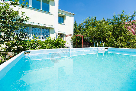 房子前面游泳池的游泳池建筑学阳光财产水池木头晴天泳池游泳天蓝色天空图片