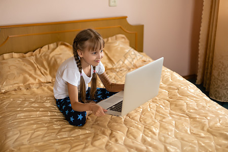 免费教育 业余时间 技术和互联网概念     家里有笔记本电脑的小女孩瞳孔玩家孩子女孩小学生学习学者青春期冲浪学生图片