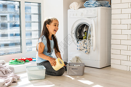 美丽的女孩小帮手在家洗衣服时玩得很开心 打球也很好玩衣服乐趣主妇洗衣店机器琐事纺织品垫圈卫生婴儿图片